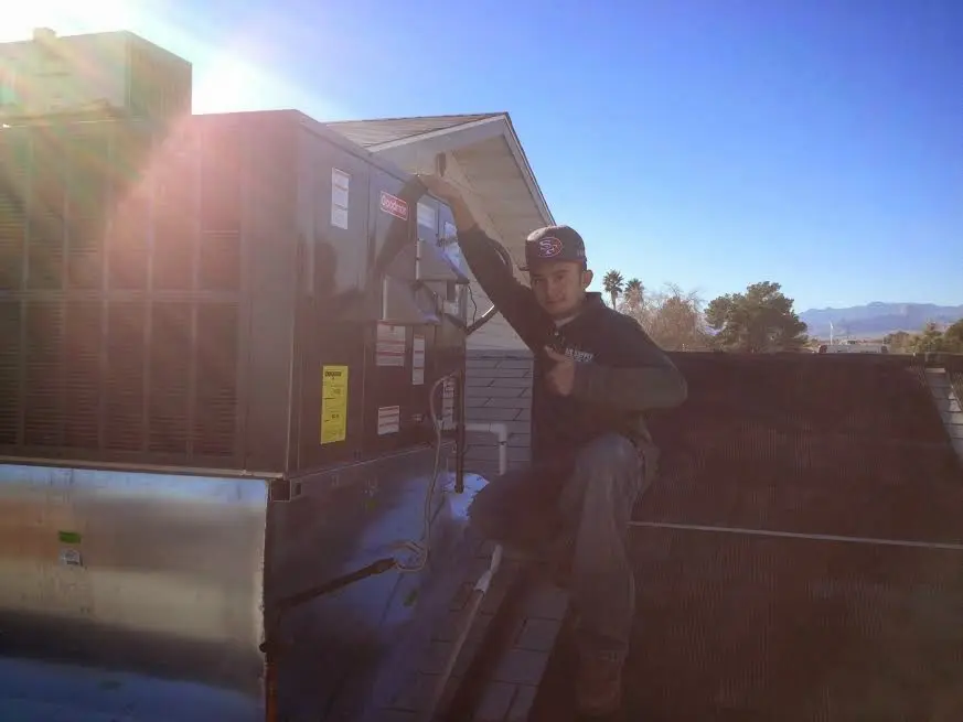 HVAC technician performing Air Duct Repair on a rooftop unit in Mentor-on-the-Lake